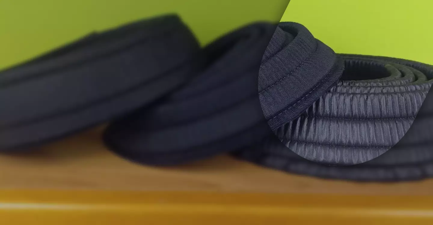 Collarini in tessuto tecnico blu e nero arrotolati